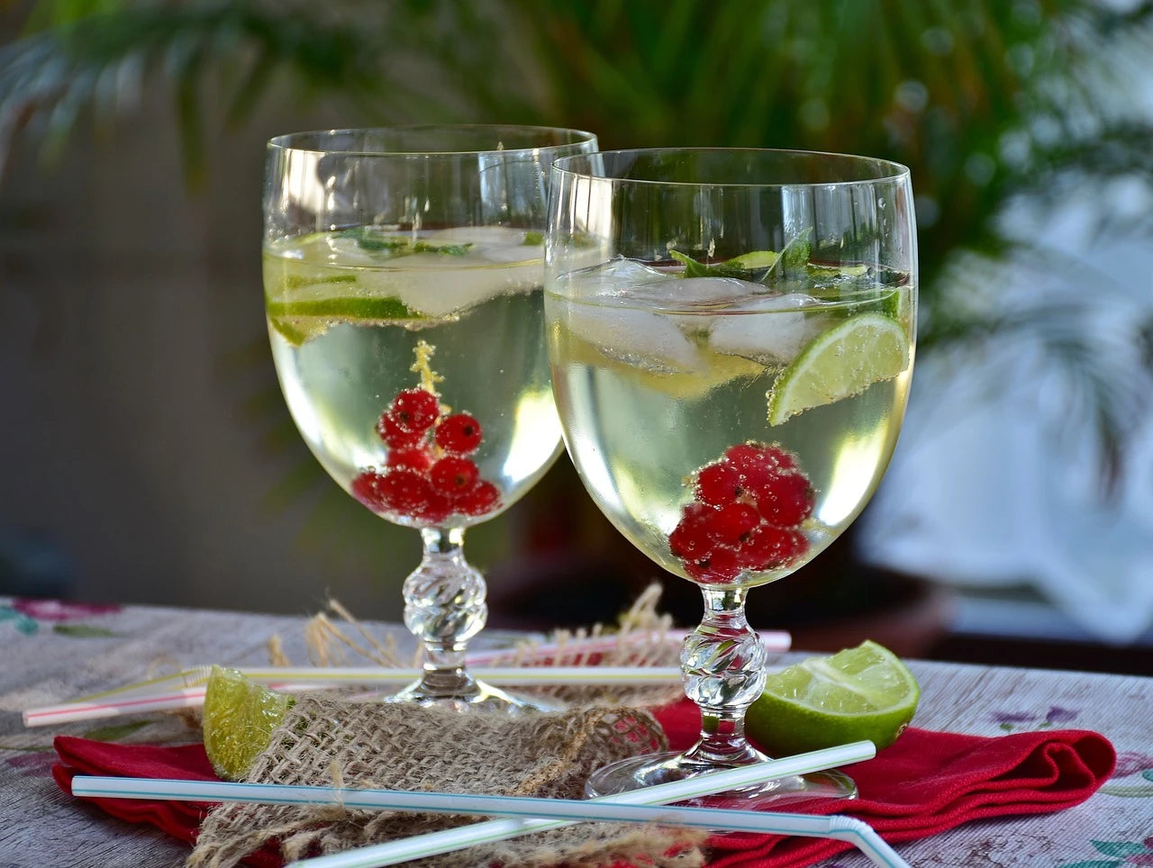 a glass filled with sparkling water and cherries, with bubbles rising against a dark backdrop.