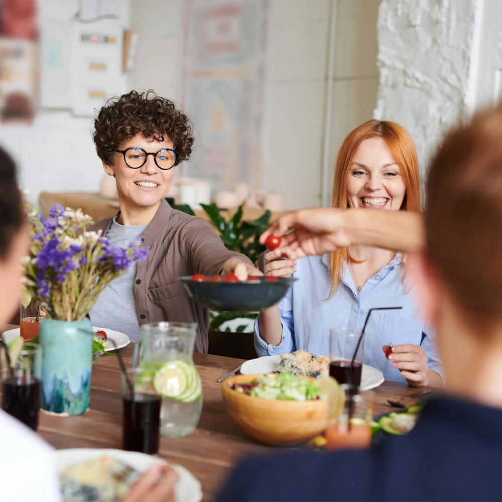 Friends sharing a meal at a dining table, enjoying a joyful  Soda Water